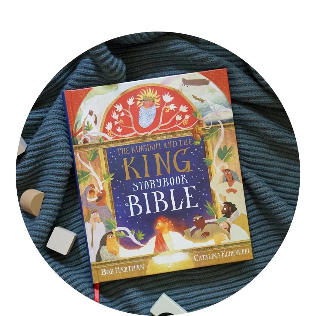 Photograph of The Kingdom and the King Storybook Bible on a ribbed knit blanket with some wooden blocks spread around it