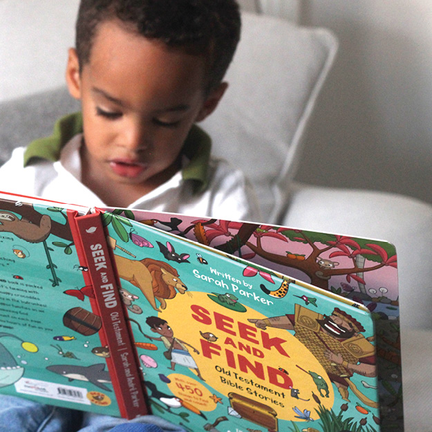 Photography of boy reading Seek and Find: Old Testament Bible Stories