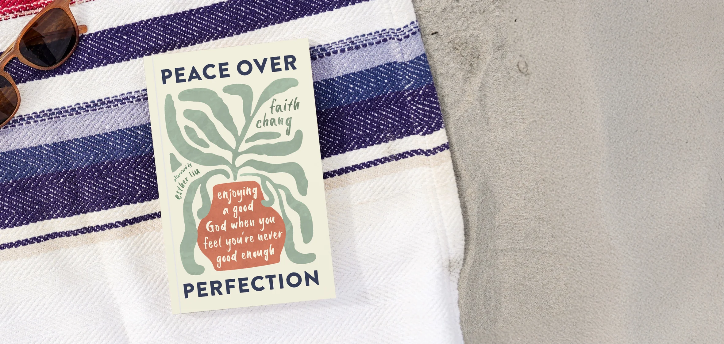 Photograph of Peace over Perfection on a beach blanket with some sand and sunglasses
