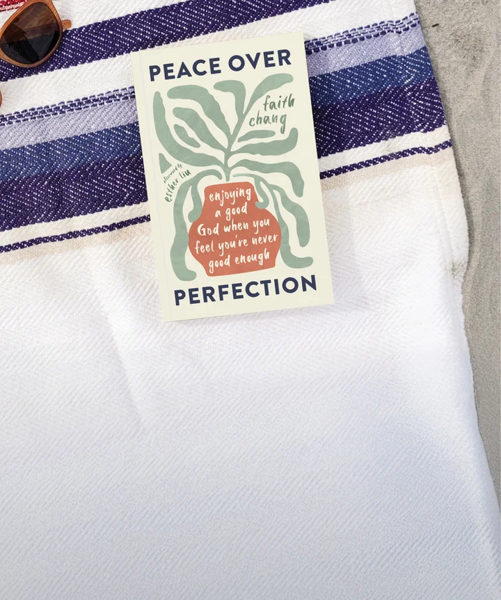 Photograph of Peace over Perfection on a beach blanket with some sand and sunglasses